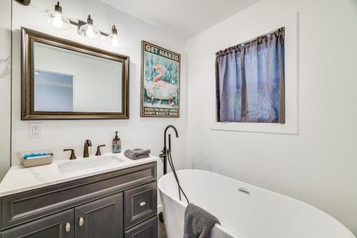 a bathroom with a tub and a sink and a mirror at Poconos Getaway with Indoor and Outdoor Pool Access! in Gouldsboro