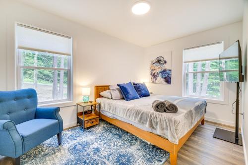 a bedroom with a bed and a blue chair at Poconos Getaway with Indoor and Outdoor Pool Access! in Gouldsboro