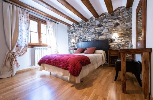 ein Schlafzimmer mit einem Bett und einer Steinmauer in der Unterkunft Esera Room in Benasque