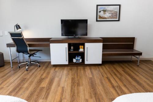 a room with a desk with a television and a chair at Hampton By Hilton San Jose Airport Costa Rica in Alajuela City