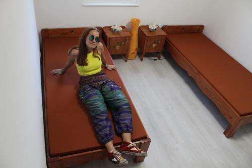 a girl laying on a bed in a room at Borács Winedégház in Bogács