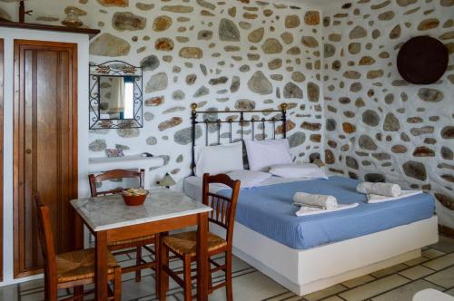 Agios GeorgiosにあるVilla Peristeriのベッドルーム1室(ベッド1台、テーブル、椅子付)