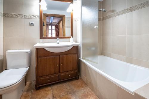 uma casa de banho com um lavatório, um WC e uma banheira em Esera Room em Benasque