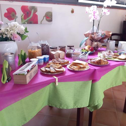 een tafel met borden eten op een paarse tafeldoek bij Agriturismo la Martina in Macchiascandona