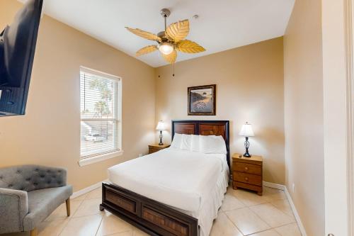 a bedroom with a bed and a chair and a television at Escape Condominiums #7 in South Padre Island