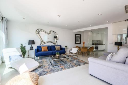 een woonkamer met een blauwe bank en een tafel bij Atico impresionante y centrico in Madrid