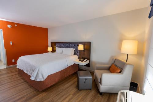 a hotel room with a bed and a chair at Hampton By Hilton San Jose Airport Costa Rica in Alajuela City