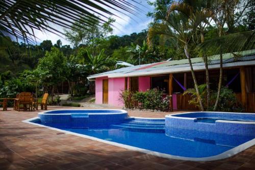 ein Haus mit einem Pool vor einem Haus in der Unterkunft Pura Natura Lodge Arroyo in Sábalo