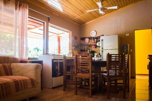 eine Küche mit einem Tisch und Stühlen sowie einem Kühlschrank in der Unterkunft Pura Natura Lodge Arroyo in Sábalo