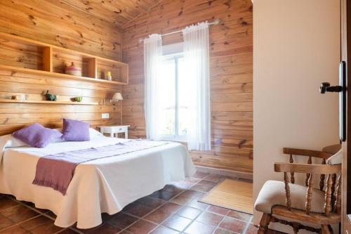 1 dormitorio con cama blanca y ventana en Casa de Madera del Turullote, en Écija