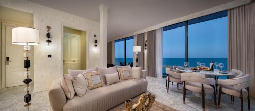 a living room with a couch and a table with chairs at Blue Sea Karpasia Hotel in Rizokarpaso
