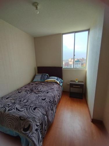 um quarto com uma cama e uma grande janela em Apartamento Fátima em Lima