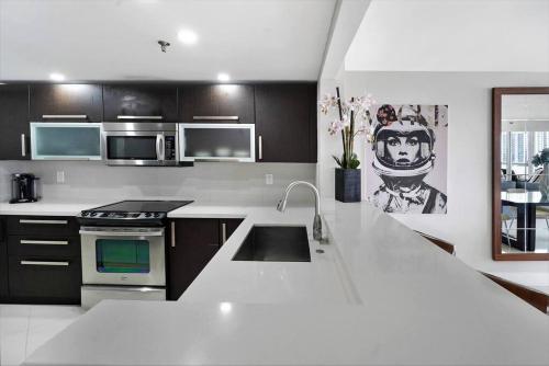 a kitchen with a white counter top with a sink at Meet Me in Miami! Impressive Miami Skyline Views in Miami