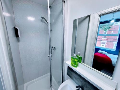a bathroom with a shower and a toilet and a mirror at Berridge Solo Stays - NG7 in Nottingham