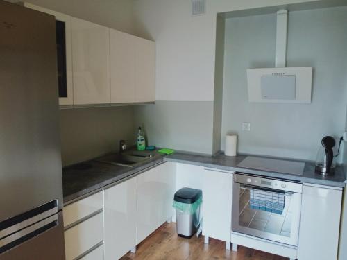 a kitchen with white cabinets and a stove at Apartament4U - Olimpijskie Ogrody in Suwałki
