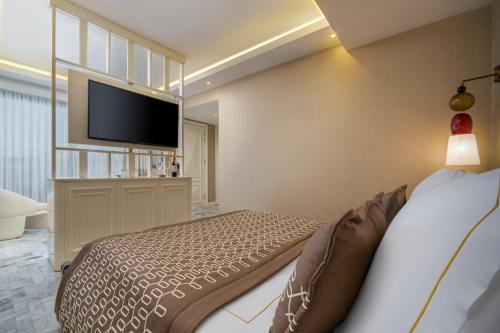 a bedroom with a bed and a flat screen tv at Blue Sea Karpasia Hotel in Rizokarpaso