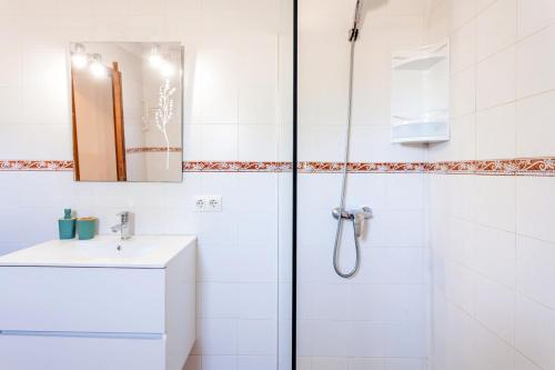 a white bathroom with a shower and a sink at Casa Antigua in Santanyi