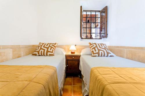two beds sitting next to each other in a room at Casa Antigua in Santanyi