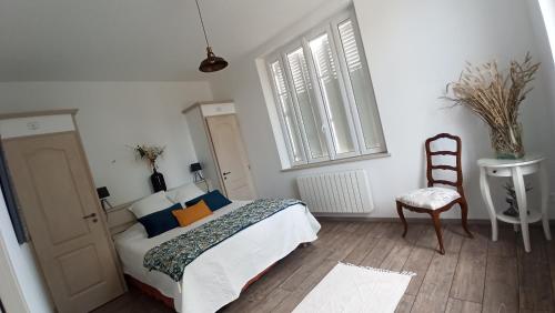 a bedroom with a bed and a chair and a window at Gîte à la campagne -maison individuelle -Piscine in Semblançay