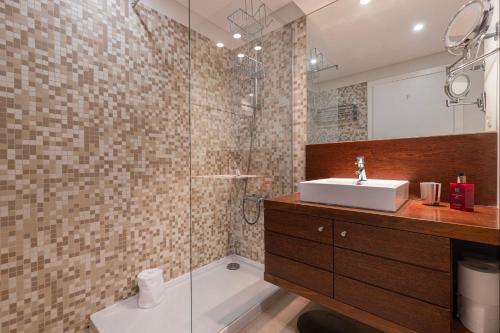 uma casa de banho com um lavatório e um chuveiro em Lovely 1 BDR Apartment With Pool by LovelyStay em Lisboa