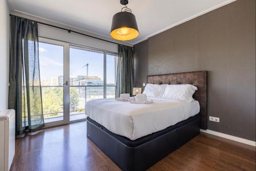 1 dormitorio con cama grande y ventana grande en Lovely 1 BDR Apartment With Pool by LovelyStay, en Lisboa