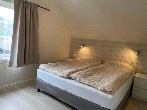 a small bed in a room with a window at Høgset in Austefjorden