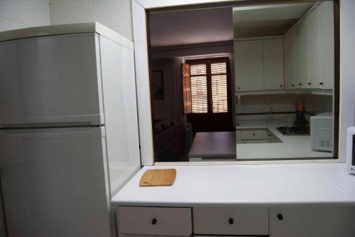 a kitchen with a mirror and a white refrigerator at Los Vetones in Ciudad-Rodrigo