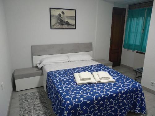 ein Schlafzimmer mit einem Bett mit zwei Büchern darauf in der Unterkunft Los Vetones in Ciudad-Rodrigo