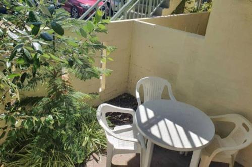 two white chairs and a table on a patio at Villa 2 Pool Spa Beach Sea! in Mandurah