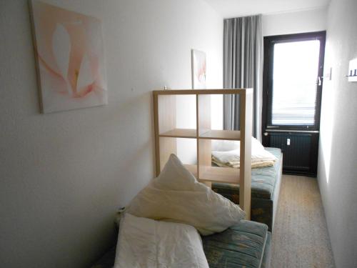 ein Wohnzimmer mit einem Sofa und einem Regal in der Unterkunft Ferienwohnung L408 für 2-4 Personen an der Ostsee in Brasilien