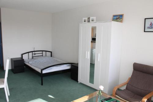 ブラズィリアンにあるFerienappartement K312 für 2-3 Personen in Strandnäheのベッドと椅子付きの小さな部屋です。