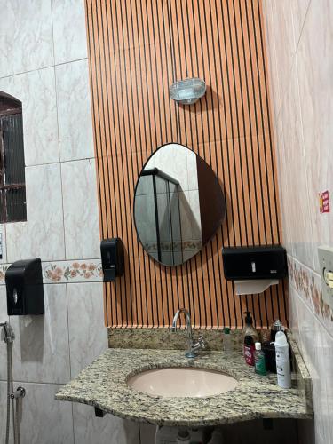 a bathroom with a sink and a mirror at Quarto duplo in Belo Horizonte