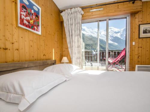 une chambre avec un lit et une grande fenêtre dans l'établissement Appartement à Chamonix avec terrasse, parking, local à skis - FR-1-343-172, à Chamonix-Mont-Blanc