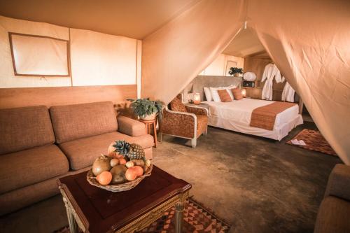 a living room with a couch and a bed in a tent at Vichayito Bungalows & Carpas by Aranwa Hotels in Vichayito