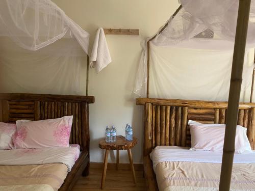 Rafiki Safari Lodge Bwindi في Kinkizi: غرفة نوم بسريرين بطابقين وطاولة
