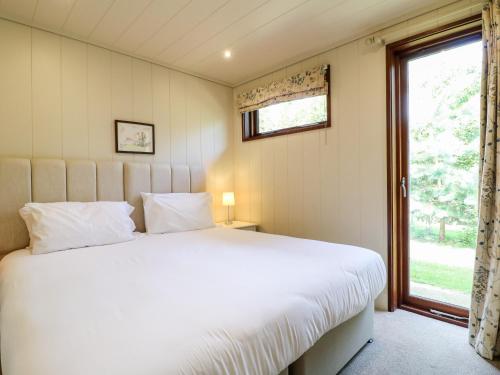 a bedroom with a large white bed and a window at Tickencote in Cottesmore