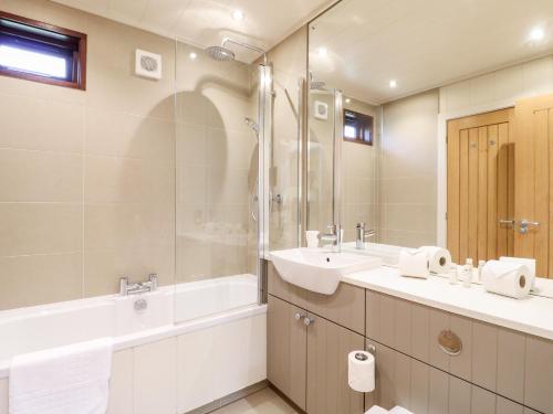 a bathroom with two sinks and a tub and a shower at Tickencote in Cottesmore