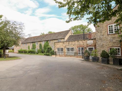 an empty driveway in front of a brick building at Clipsham in Cottesmore