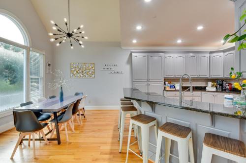 a kitchen with white cabinets and a table and stools at Grand Lakefront Home in Hartwell with Game Room! in Hartwell