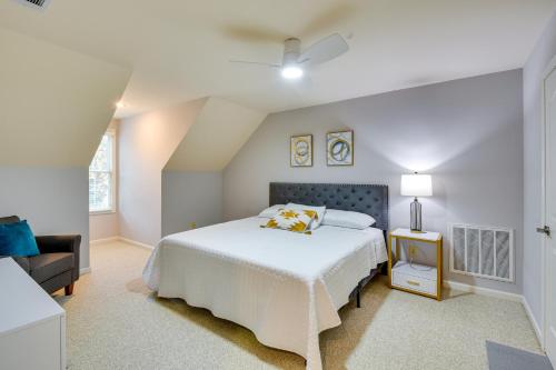 a white bedroom with a bed and a chair at Grand Lakefront Home in Hartwell with Game Room! in Hartwell