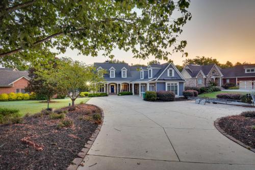 a house with a driveway in a residential neighborhood at Grand Lakefront Home in Hartwell with Game Room! in Hartwell