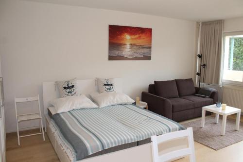 um quarto com uma cama e um sofá em Ostseeappartement K014 em Brasilien