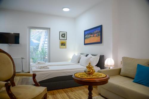 a hotel room with a bed and a couch at Apartman Centar in Sremski Karlovci