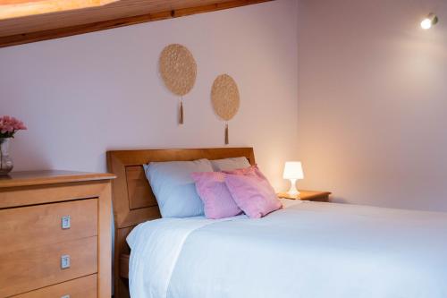 um quarto com uma cama com duas almofadas cor-de-rosa em S Bernardino’s beach house em São Bernardino