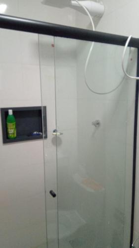 um chuveiro com uma porta de vidro na casa de banho em Flat mobiliada em Sinop