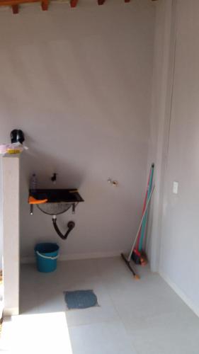 um quarto com uma parede branca e uma vassoura em Flat mobiliada em Sinop