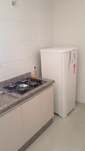 uma cozinha com um fogão e um frigorífico branco em Flat mobiliada em Sinop