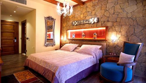 a bedroom with a bed and a stone wall at Kazdaglari Karye Müze Hotel in Kucukkuyu