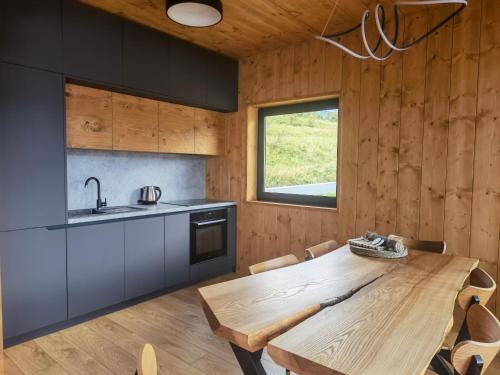 a kitchen with a wooden table and a sink at Chalet Smreky in Telgárt