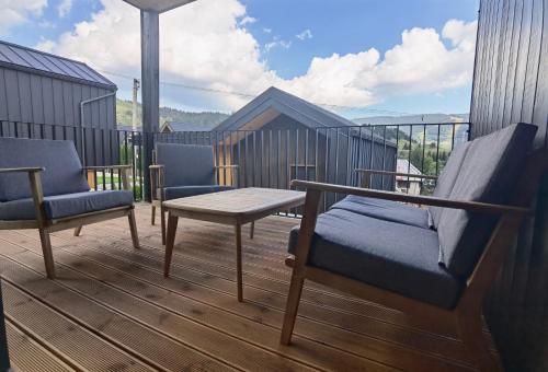 a patio with two chairs and a table on a deck at Chalet Smreky in Telgárt